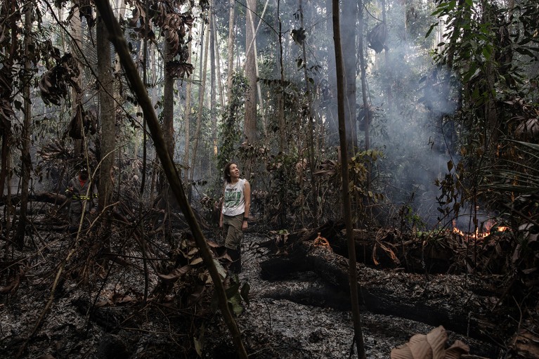 Erika Berenguer stands in a burning forest