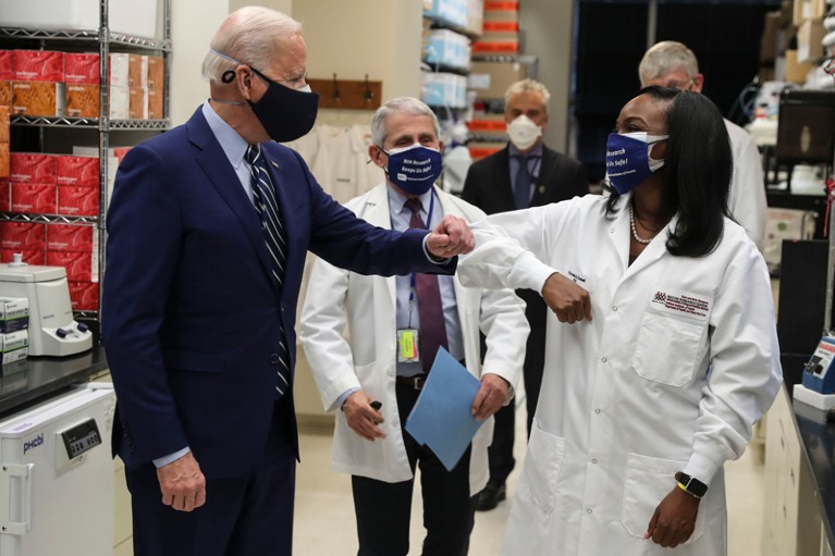 Kizzmekia Corbett-Helaire bumps elbows with President Joe Biden during a tour of her lab at the National Institutes of Health