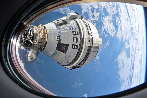 A view of the Boeing's Starliner spacecraft docked to the International Space Station seen from a window on the SpaceX Dragon Endeavour spacecraft docked to the adjacent port.