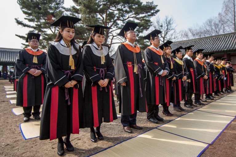 University graduates stand and wait during a Sungkyunkwan University traditional graduate ceremony in Seoul