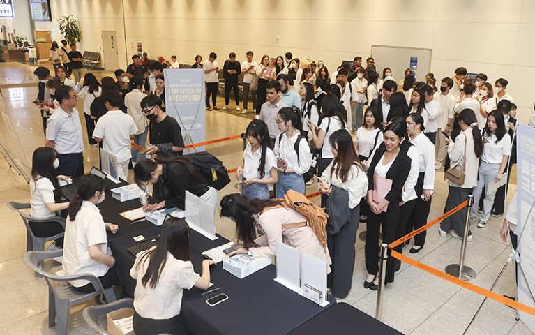 Students wait in line to submit their applications at a local job fair