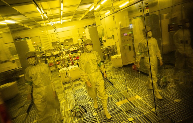 Wearing protective clothing PhD student Kei Misumi working in a clean room at Tokyo University in Tokyo.