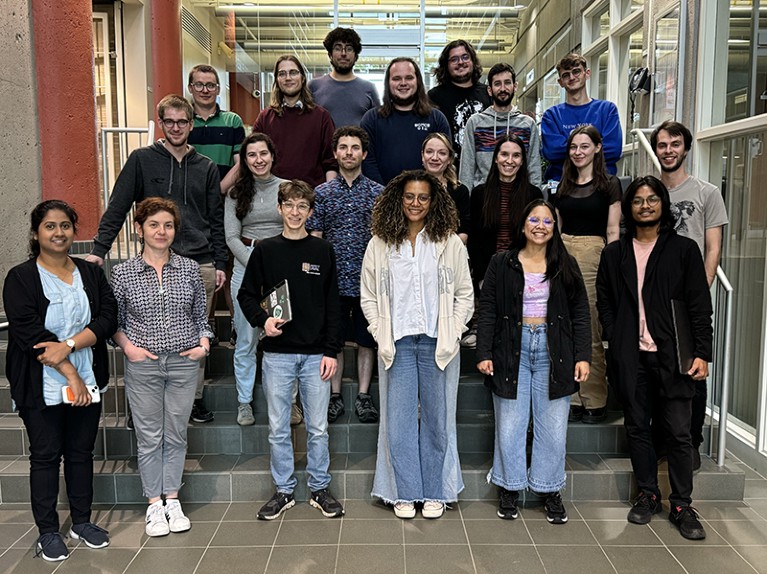 A group of participants for the coding bootcamp pose together on a set of stairs