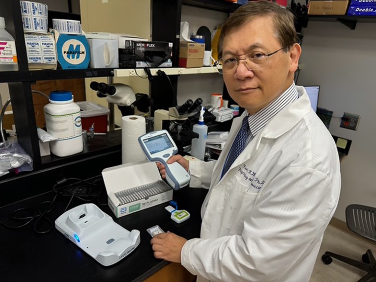 Kevin Wang examines the I-Stat Anility reader in a workstation like laboratory Credit: Troy Cai