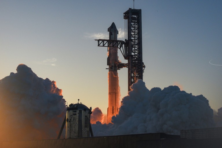 The SpaceX "Starship" rocket just about to take off, surrounded by plumes of smoke