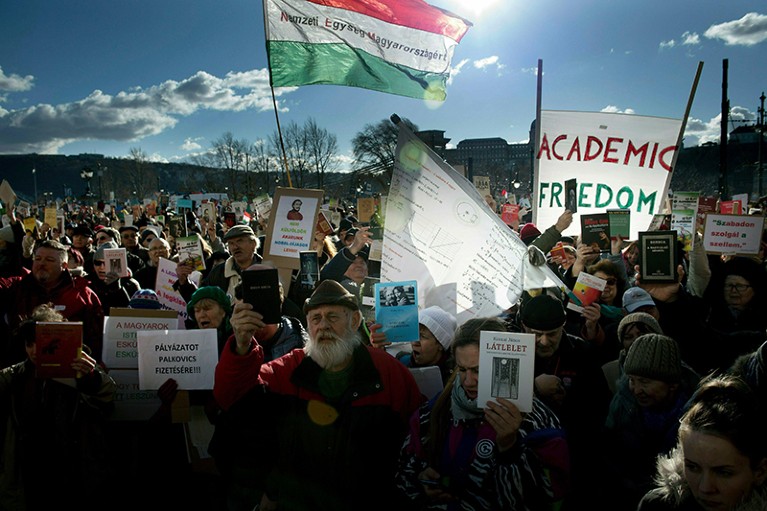 Protestors hold placards and banners outside the Hungarian Academy of Sciences