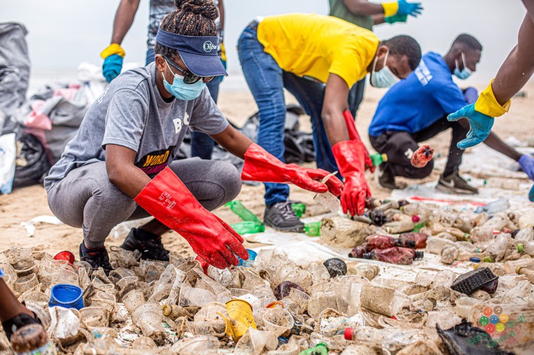 Volunteers sorting plastic waste on a beach in Ghana