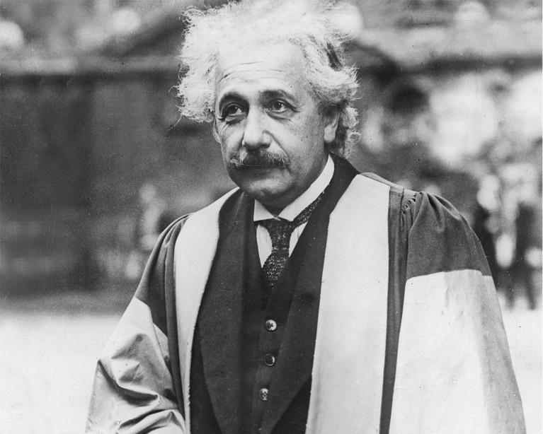 Black and white portrait of Albert Einstein, with gown as an honorary doctor of the University of Oxford, 1931.