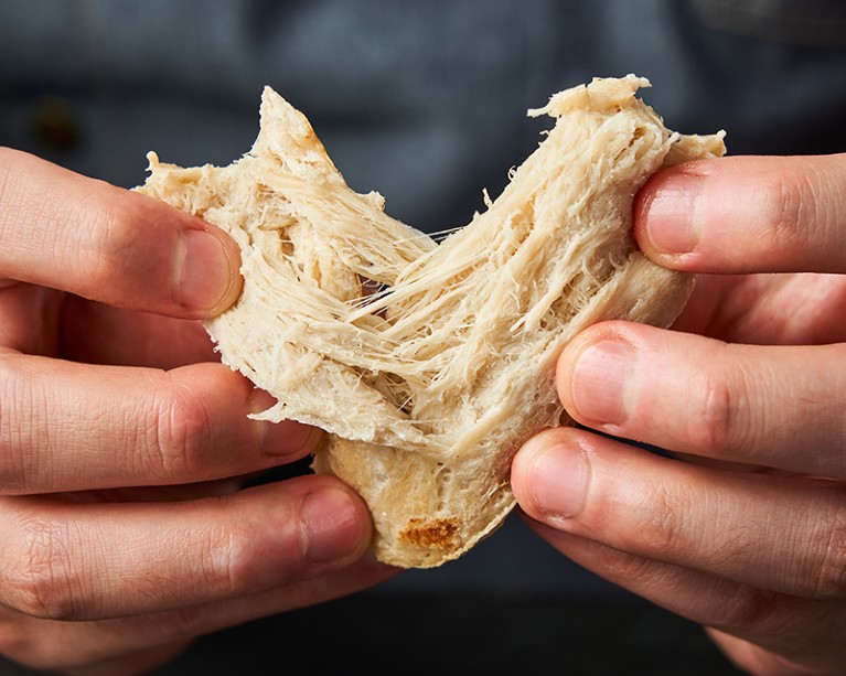 Cultivated chicken breast being opened by a person in China.