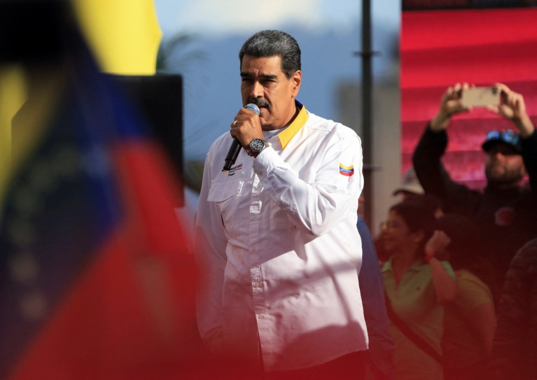 Nicolas Maduro speaks into a microphone during an election rally