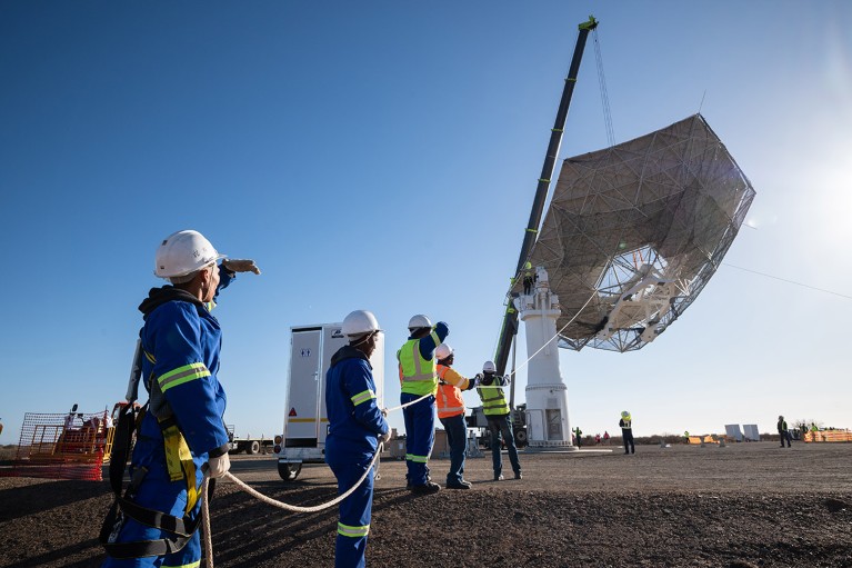 A crane lifts the main reflector onto the pedestal for the first SKA-Mid production dish on site in South Africa.