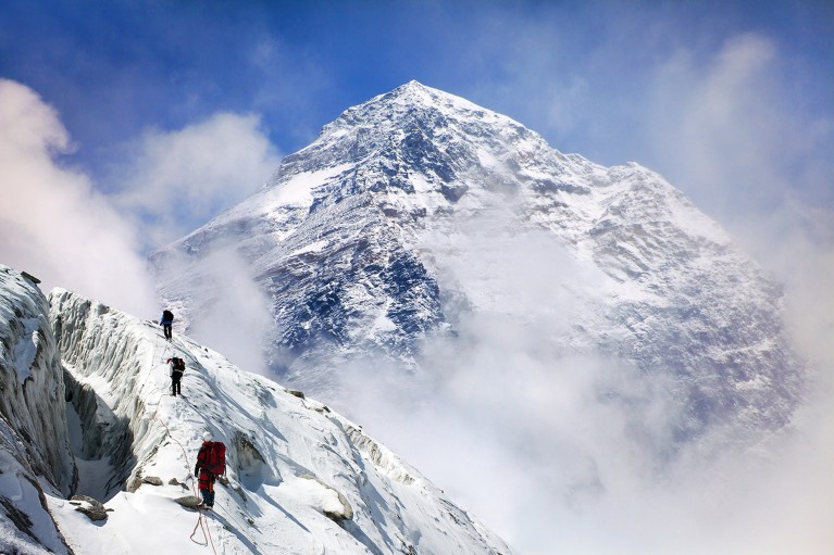 Mount Everest with a group of climbers in the foreground, making their ascent.