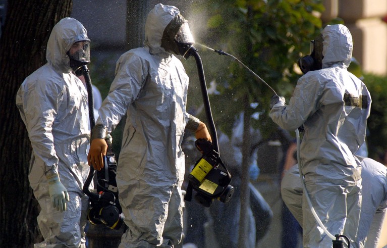 Three people in hazmat suite doing an Anthrax search on Capitol Hill.