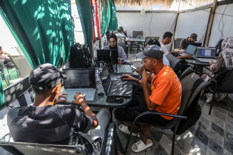 Young Palestinians use laptops at a cafe in Gaza which provides internet