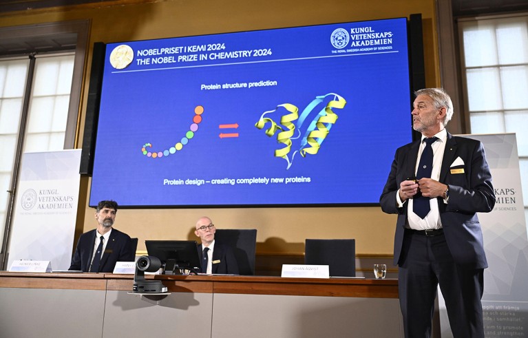 Johan Åqvist, right, member of the Nobel Committee for Chemistry, explains the work of David Baker, Demis Hassabis, and John M Jumper, winners of this years Nobel Prize in Chemistry at the Royal Swedish Academy of Sciences.