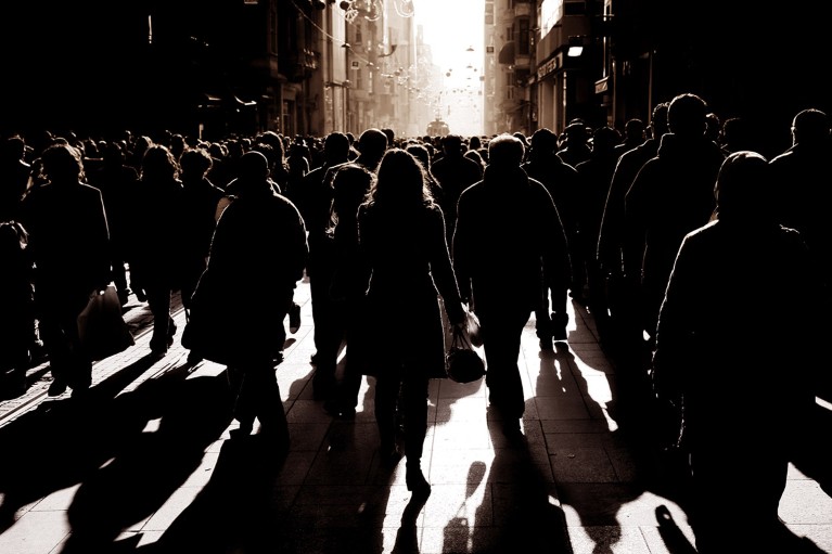 A silhouetted crowd of people walking on busy street in Istanbul, Turkey.