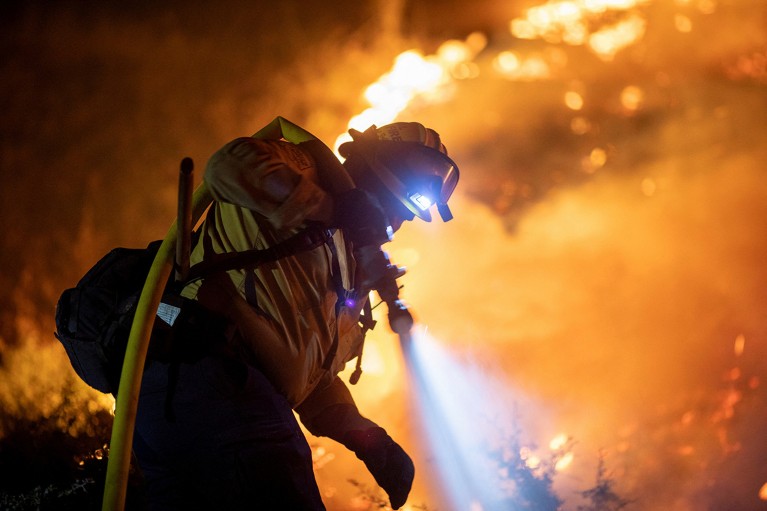 A Cal Fire firefighter sprays water on the Bridge Fire near the northeast of Los Angeles, in Wrightwood, California, U.S.