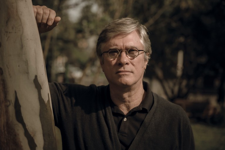 Portrait of Flavio Kapczinski leaning on a tree after the floods in Rio Grande do Sul, Brazil in July 2024.