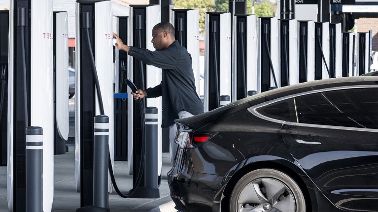 A customer charges a Tesla at a new Rove EV charging center in Santa Ana, California