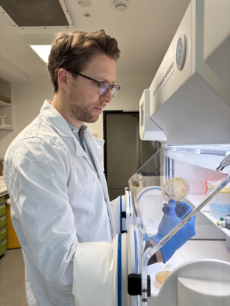 Jeremy Barr working beside an anaerobic chamber