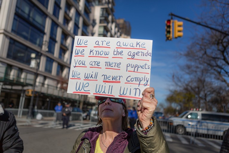 Close-up of an anti-vaccine protester holding a placard