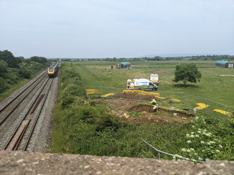 Foto del lugar de la fuga de gas en funcionamiento en Cheltenham, con el tren pasando a la izquierda