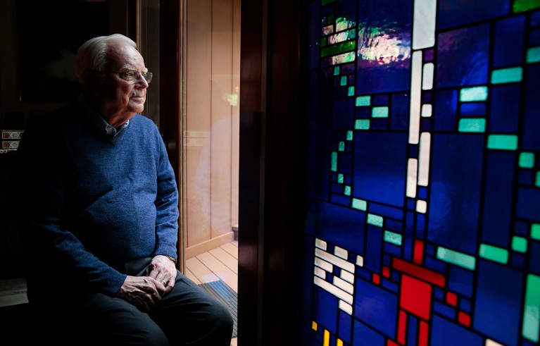 Frank Drake poses next to a stained glass window with the Arecibo Message at his home in Aptos, California.