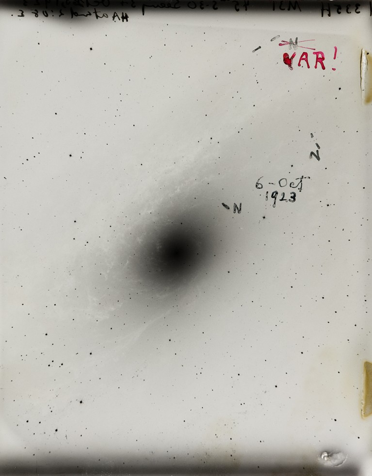 A black spot on a plate indicating a star. Black and white Hubble plate.