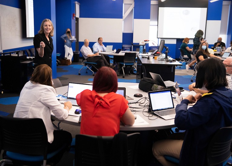 A standing Barbara Duncan is seen leading a grants training workshop to sitting participants