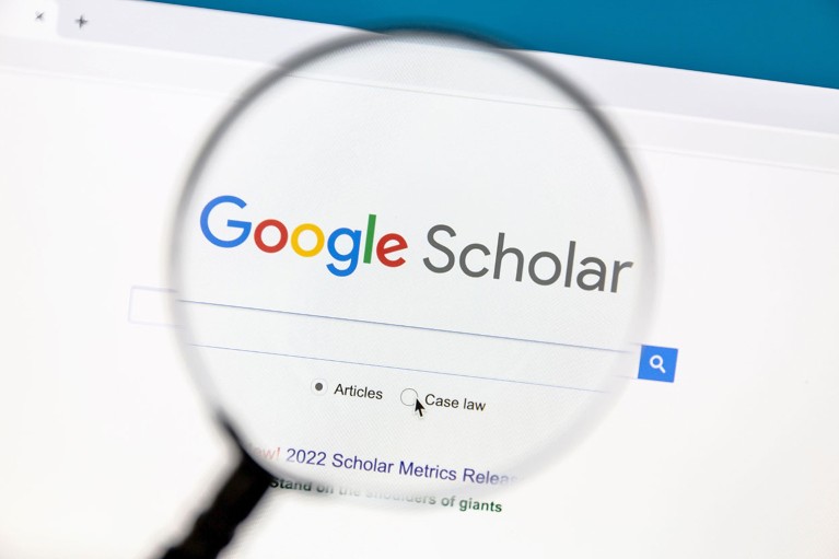 A magnifying glass highlighting the Google Scholar website on a computer screen.