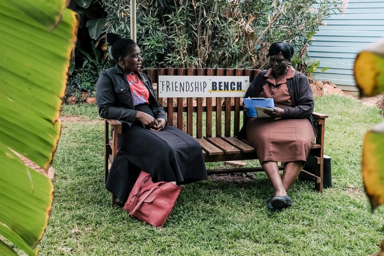 A counselor sits on a bench with a client during a private counseling session at the Friendship Bench in Harare, Zimbabwe.