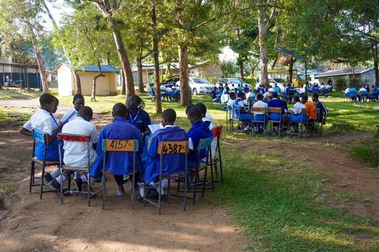 Several groups of students and mentors at a Shamiri Event Group Discussion at a girls school in Kisumu, Kenya.