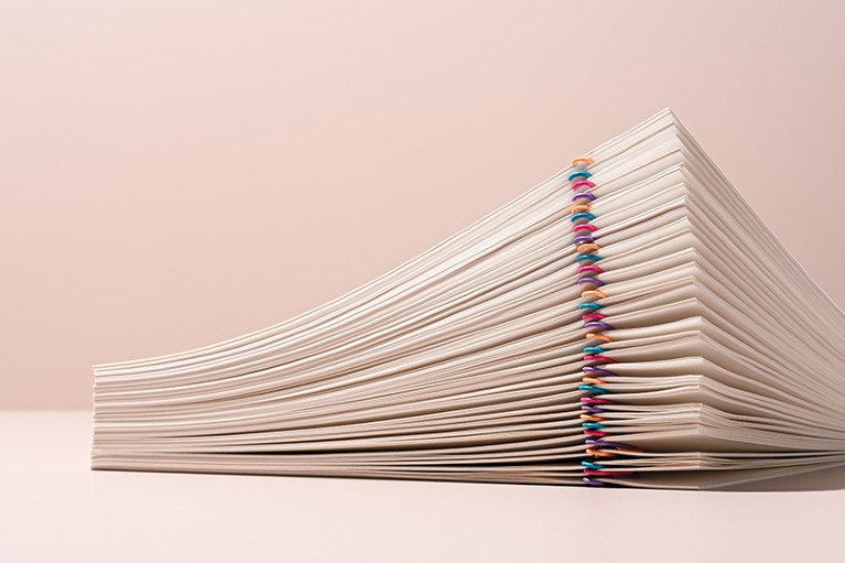 A stack of sheets of paper with many multicoloured paper clips.