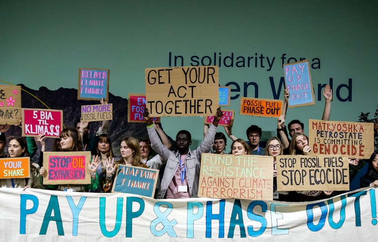 Activists stage a protest during a press conference in Blue Zone during COP29.