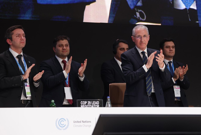 COP29 President Mukhtar Babayev (2nd from R) and Yalchin Rafiyev (L), applaud the end of the UNFCCC COP29 Climate Conference in the early hours on November 24, 2024 in Baku, Azerbaijan.