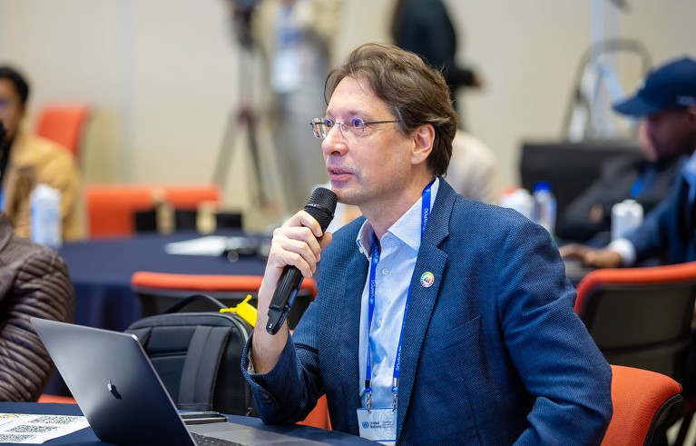 Dr Serge Stinckwich pictured speaking into a microphone.