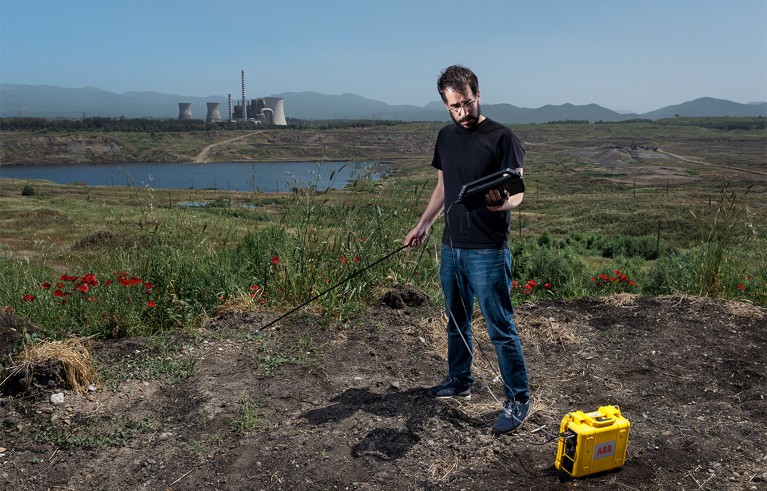 Ioannis Binietoglou holds ABB's laser-based gas analyzers as he tries to make invisible methane visible by measuring its concentration in the air near the Megalopolis coal mine.