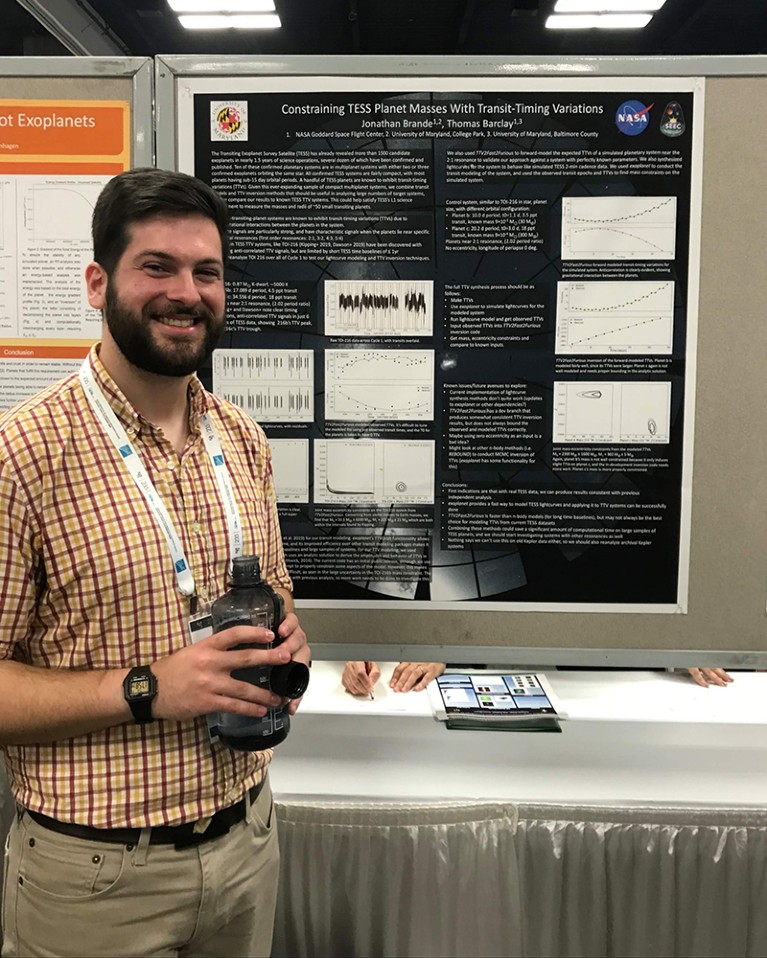 Yoni standing in front of a poster as he presents his own research