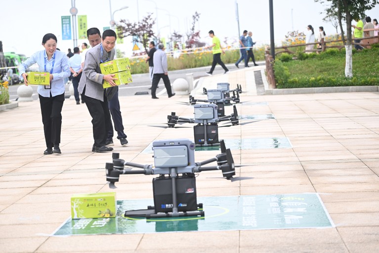 Employees unload boxes of Wushan Crispy Plums from multiple drones at Wushan Airport in Chongqing, China.