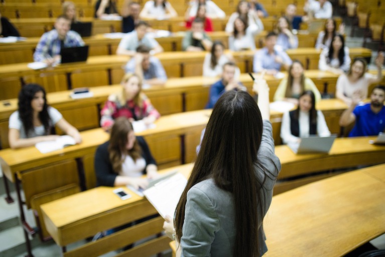 A woman delivers a lecture to students