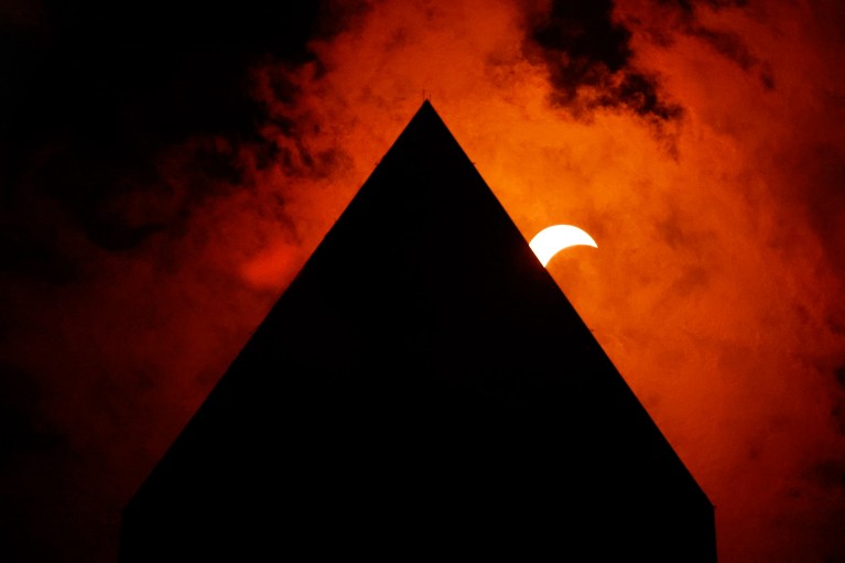 The tip of the Washington Monument in silhouette with the sun in partial eclipse during the April 2024 total solar eclipse event