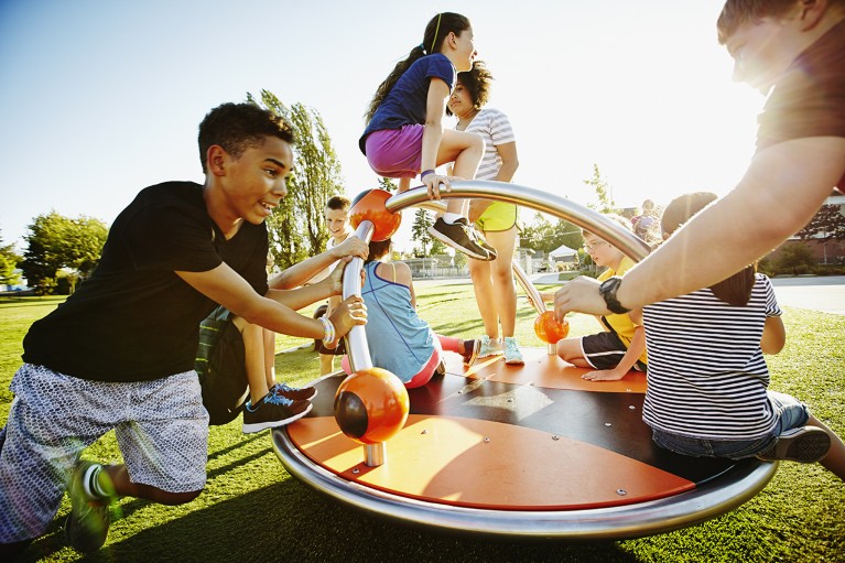 Un gruppo di bambini che giocano su una giostra nel parco giochi.