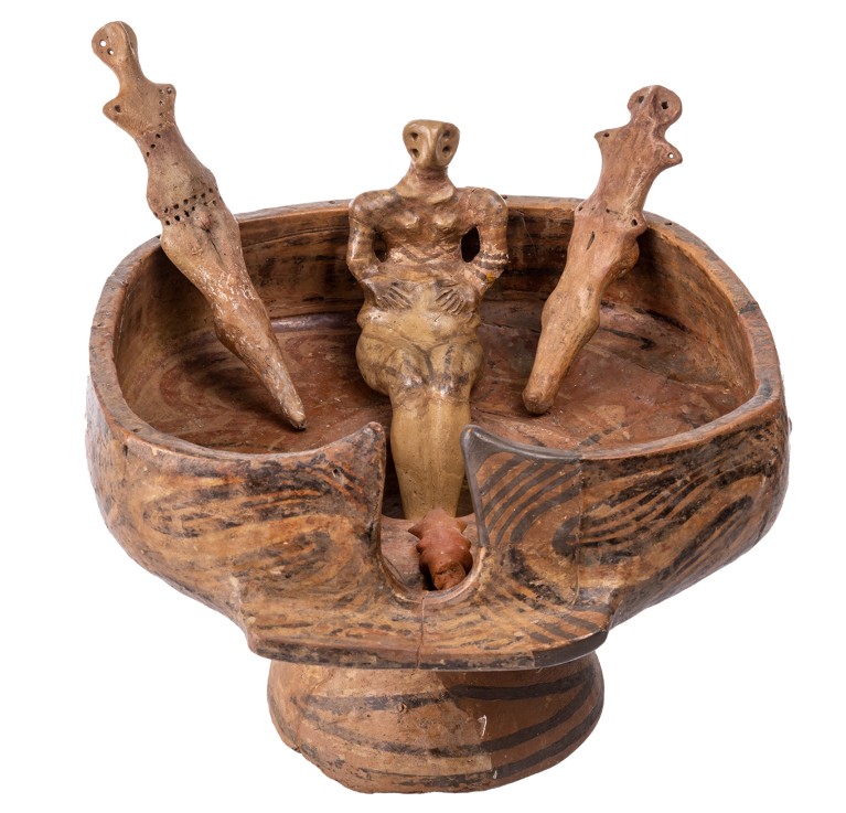 A Cucuteni sculpture from northern Romania shows a seated pregnant figurine surrounded by additional anthropomorphic statuettes.