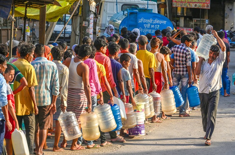 La gente hace cola para llenar un tanque de agua durante una ola de calor en Nueva Delhi, India, en 2024.