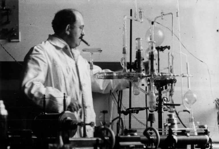 Black and white photograph of Otto Stern smoking a cigar while in his laboratory