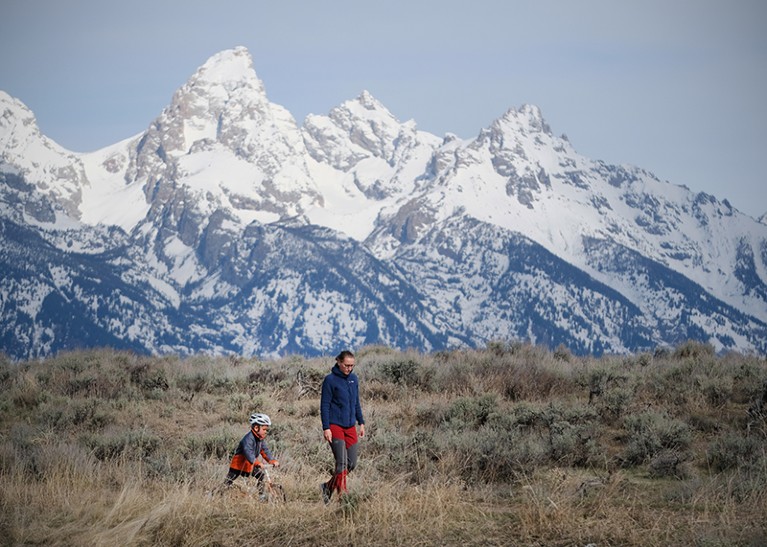 Mette and her young son are seen walking with snow covered mountains in the background