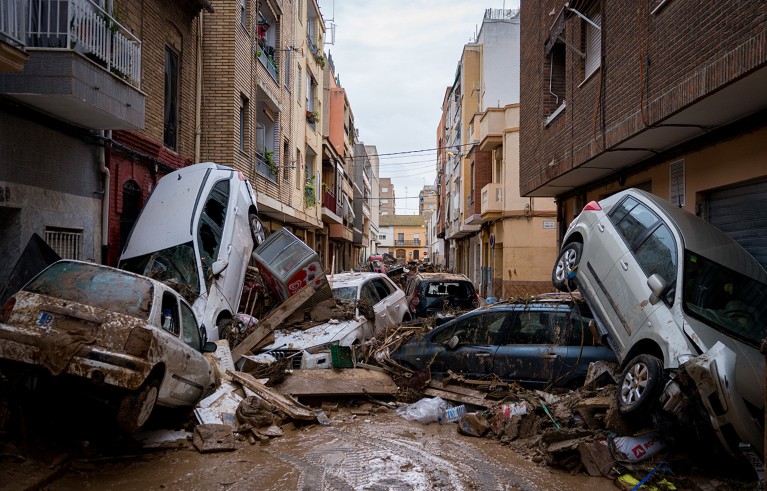 Destroyed cars and rubble are seen piled in the streets as a consequence of the floods.