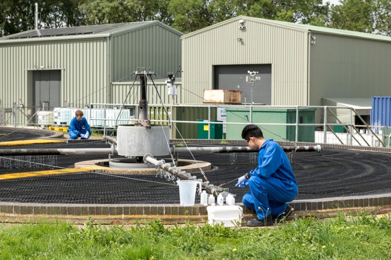 Researchers in PPE collect samples from sewage works at a wastewater research facility