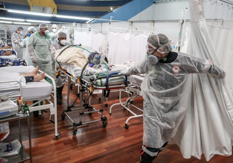 Medical staff in PPE transport a patient on a stretcher through a COVID ward in Santo Andre, Brazil.