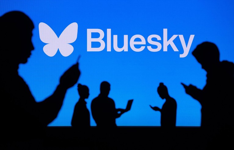 Le sagome di diverse persone che utilizzano dispositivi digitali sullo sfondo blu del logo Bluesky.